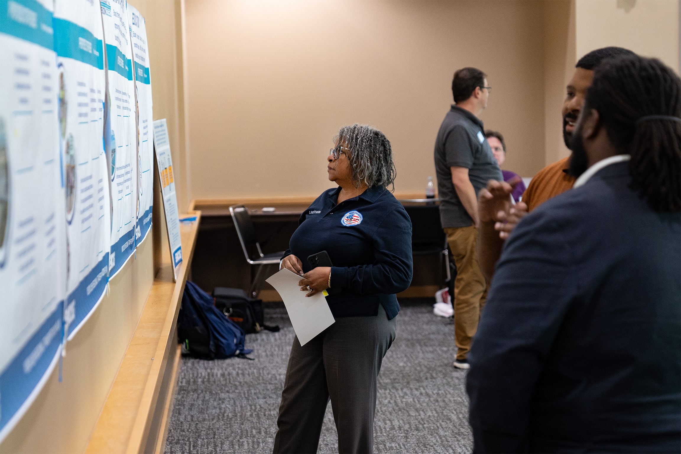 People standing and looking at draft plans