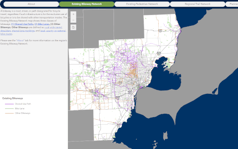Thumbnail graphic titled ‘Bike & Pedestrian Network’. Shows a stylized map of Southeast Michigan’s counties in shades of green and blue, overlaid with white-outlined lines and icons indicating planned or existing bicycle and pedestrian routes. To the right is a vertical panel with three colored bar-charts labelled ‘Miles of network’, ‘Improvement priority’, ‘Connectivity score’ (bars in orange, yellow and green). At the bottom is a dark-blue footer band with the Southeast Michigan Council of Governments logo.