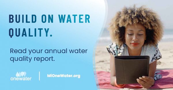 Woman reading on device, laying on the beach. Text says, Build on water quality, read your annual water quality report. One Water, mi one water dot com