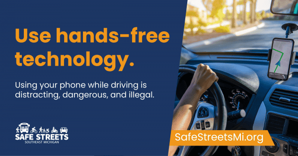 Driver with a phone mounted on the dash, with text that reads, Use hands-free technology. Using your phone while driving is distracting, dangerous, and illegal.Safe Streets Southeast Michigan logo and SafeStreetsMi.org URL are shown.