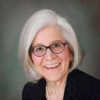 Sheila Tomkowiak, Co-Chairperson of SEMCOG’s Healthy Climate Task Force and Mayor of Grosse Pointe, smiling in a professional headshot. She is wearing glasses, a dark blazer, and a pearl necklace, posed in front of a neutral gray background.