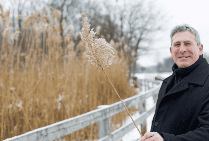 Bill Parkus, recent SEMCOG retiree standing in front of phragmites
