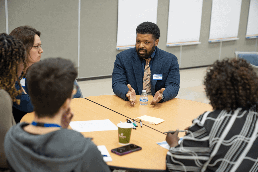 Person facing a group, talking