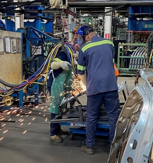 Two people working on welding with sparks flying