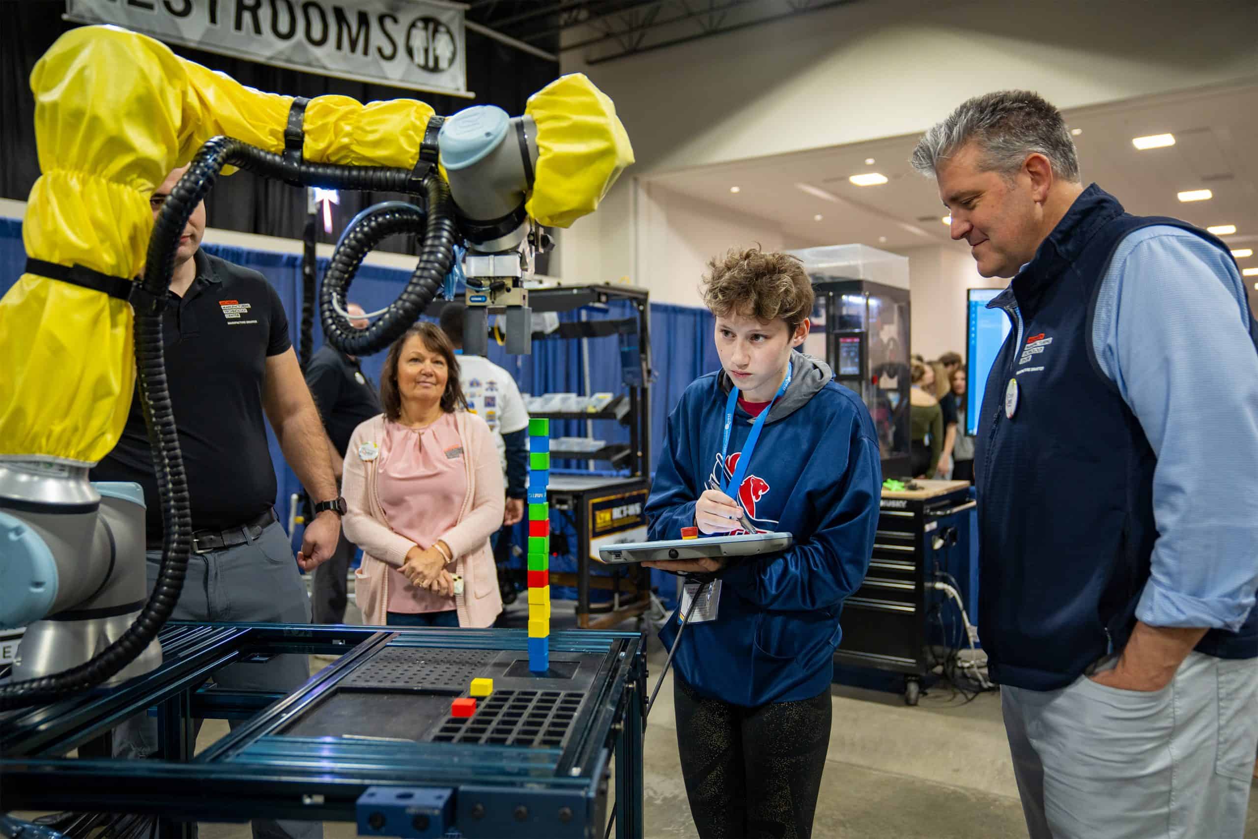 A student takes notes while observing a robot at MiCareerQuest in Novi in 2023