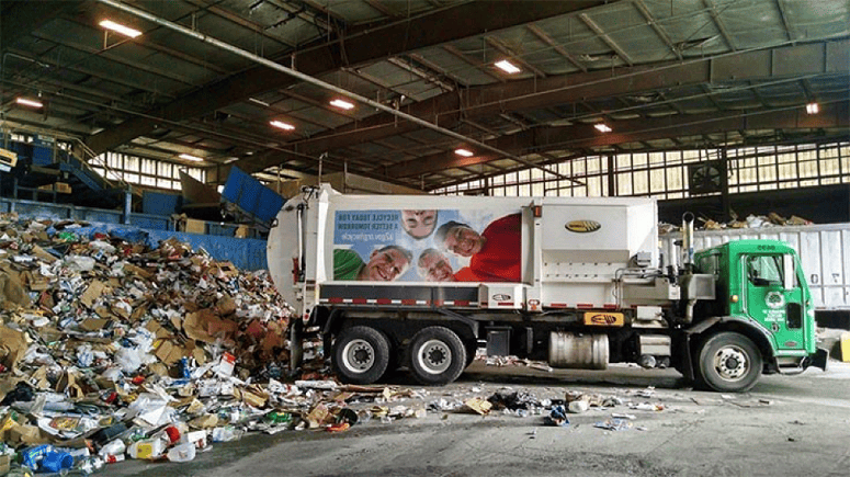 A truck drops off materials at a recycling plant