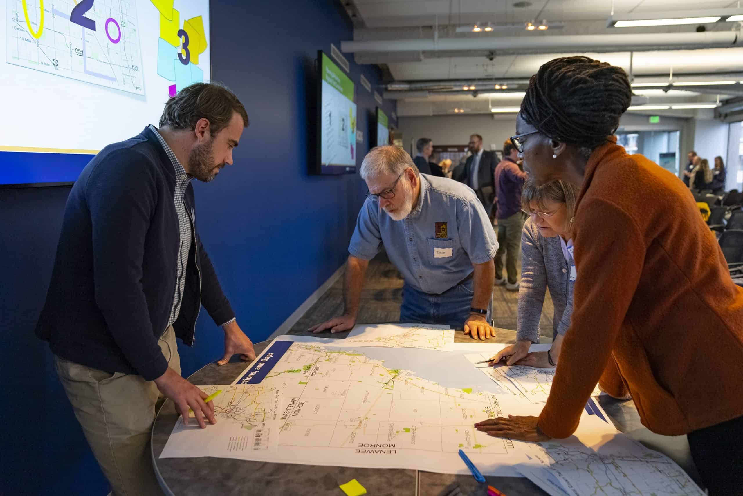 Summit attendees collaborating with map