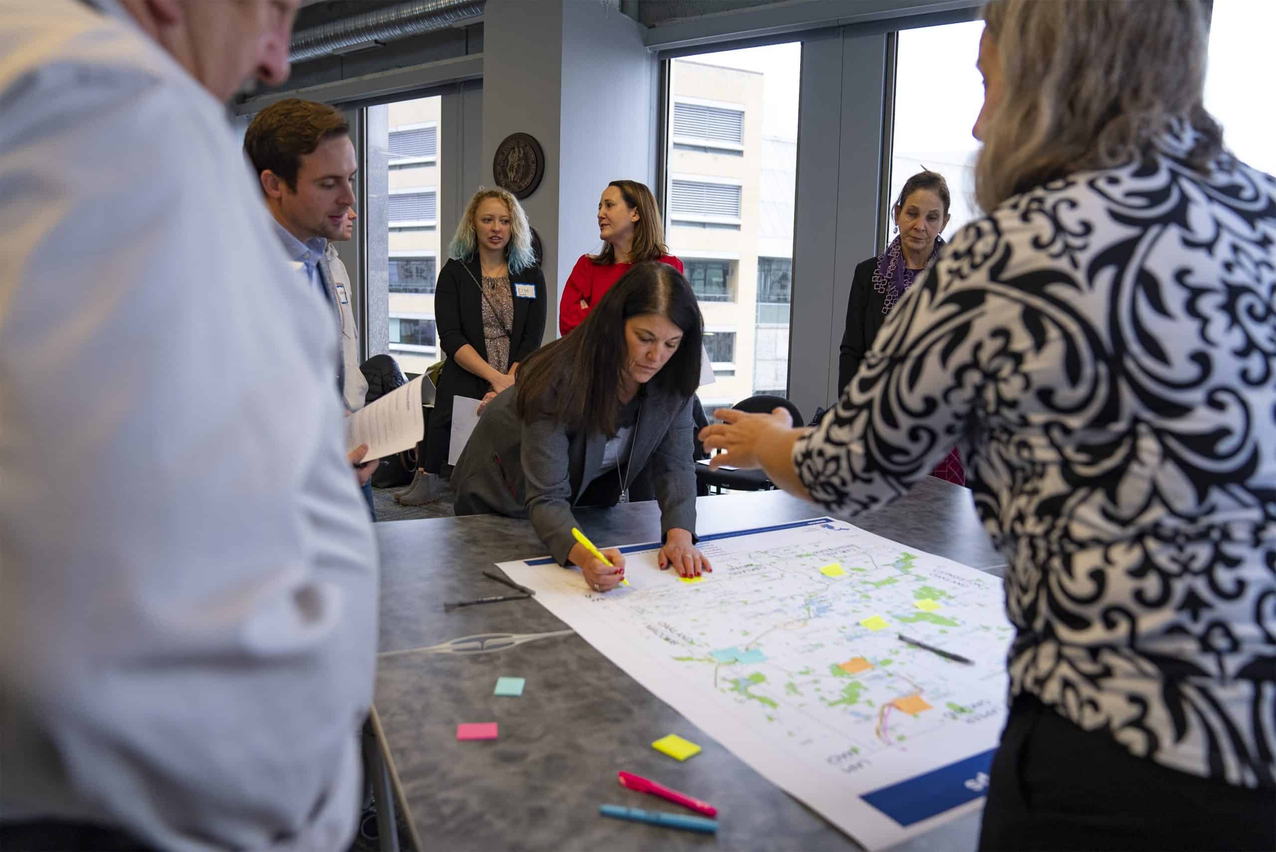 Attendee writing on map with surrounding group