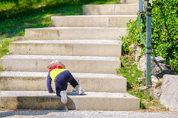 Child climbing up large steps