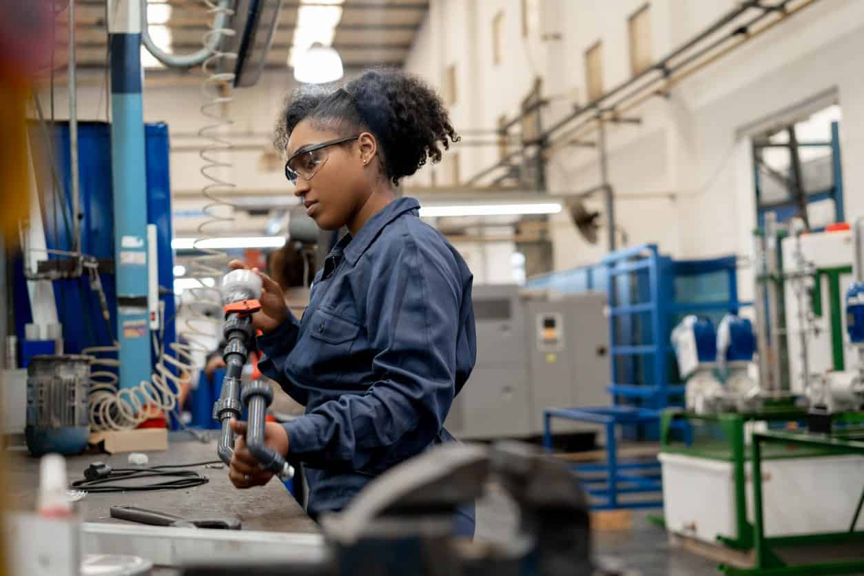 person working in a warehouse, wearing safety googles