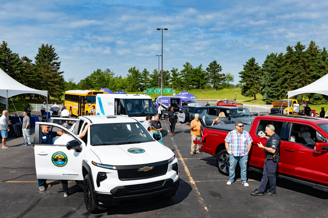 outdoor event with cars, people, and tents