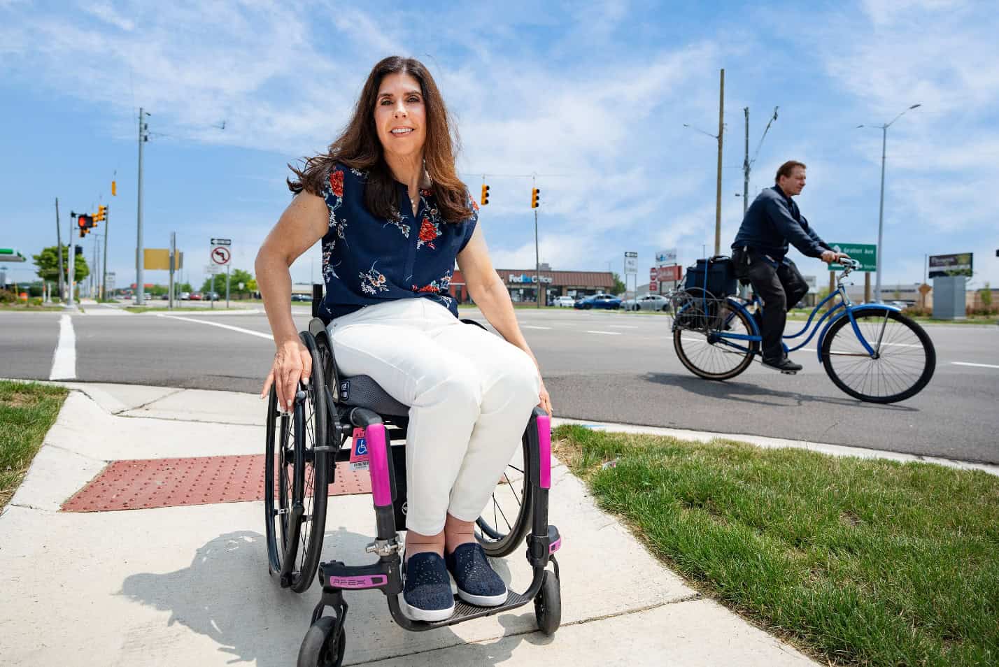 pedestrain crossing the street with bicyclist in background pedestrain crossing the street with bicyclist in background