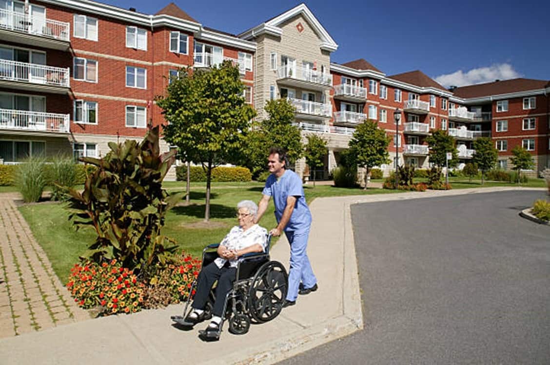 someone outside pushing someone in a wheel chair