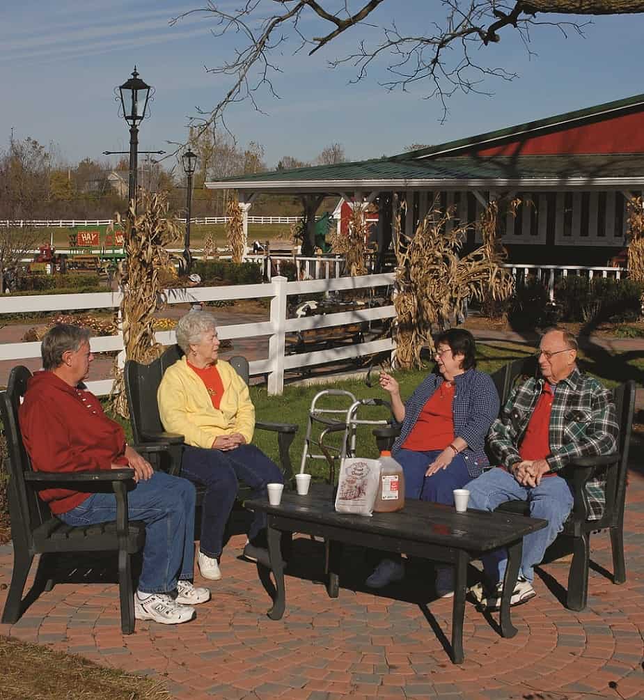 four people sitting and talking at a cider mill