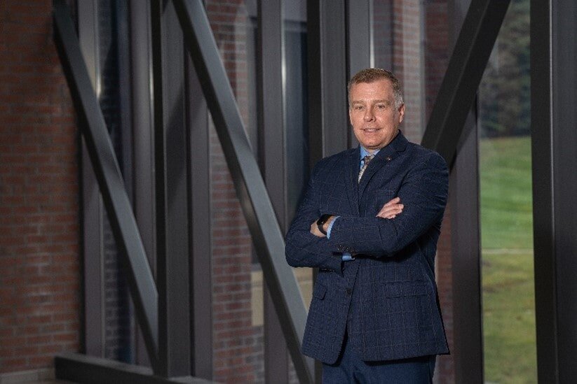 person standing with arms crossed in a suit