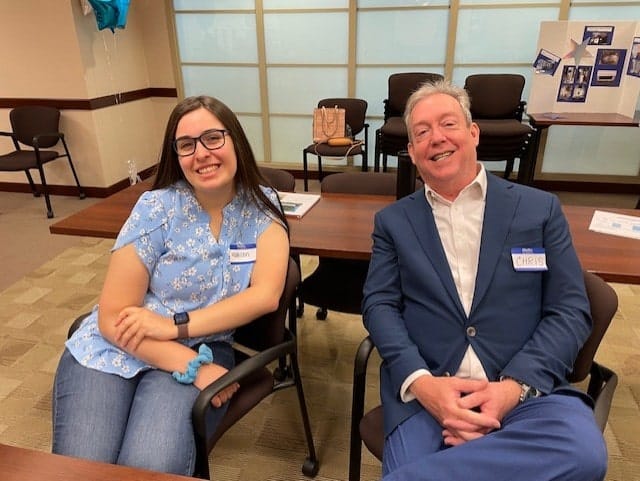 Two people sitting and smiling