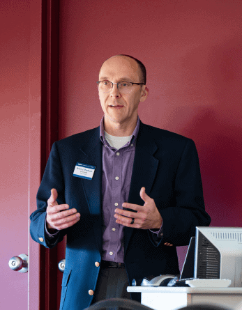 Expert giving presentation on regional planning and transportation initiatives at SEMCOG conference.