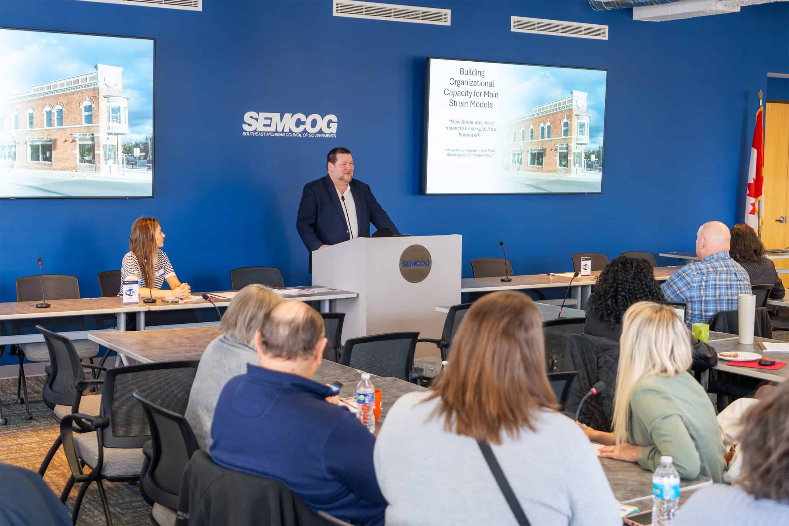 Speaker standing at SEMCOG podium during meeting