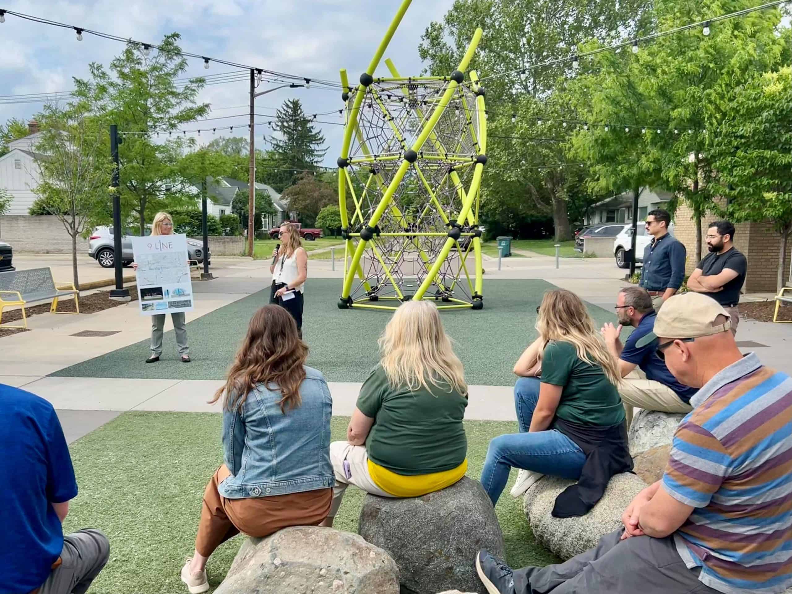 Crowd listening to 9Line presentation in the park