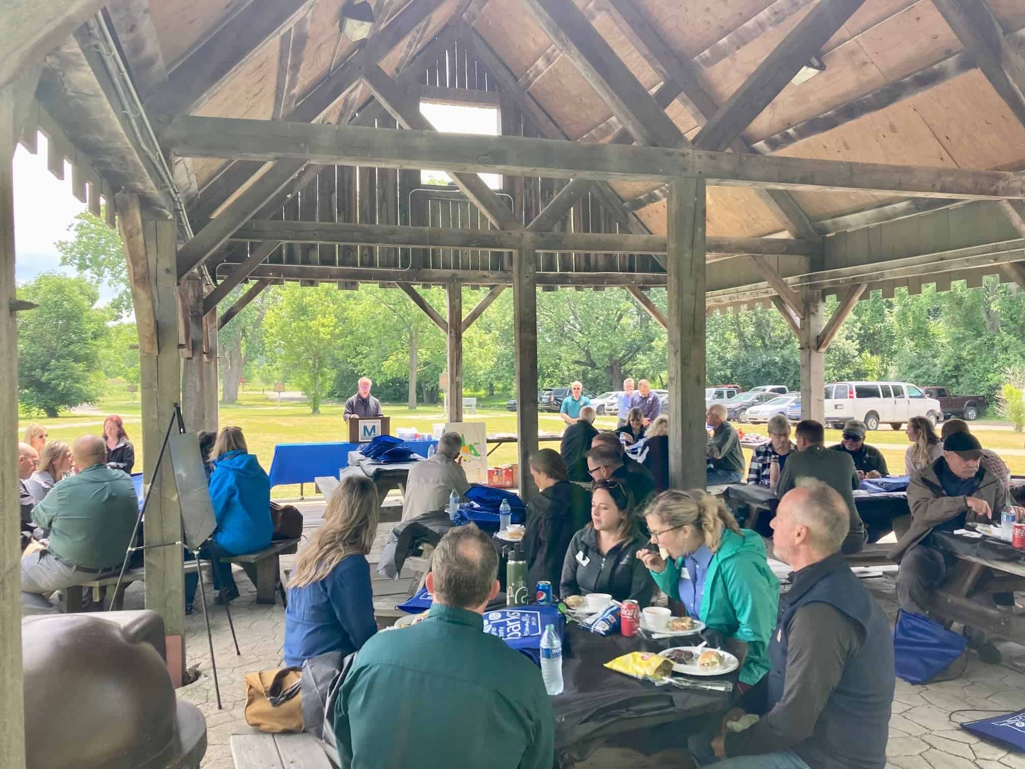 group of people eating outdoors in a park pavilion