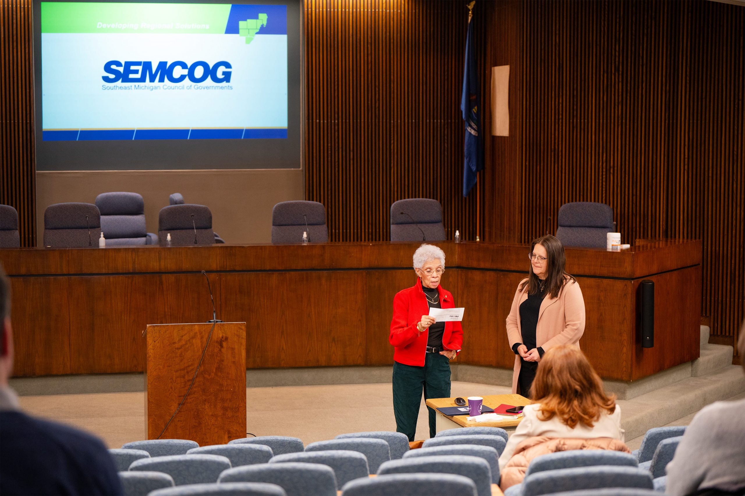 Two people standing at front of auditorium