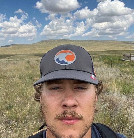 selfie photo of man in hat with clouds