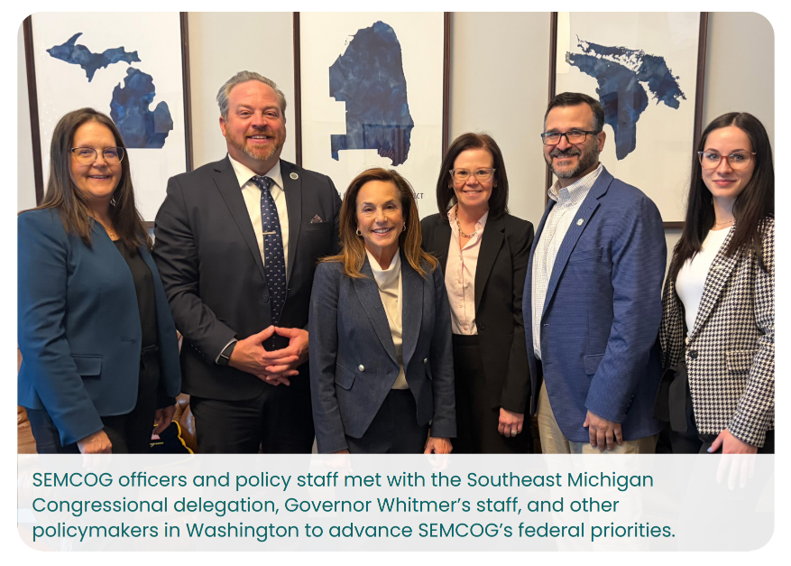 A group of six people stands smiling indoors. Behind them are framed blue maps hanging on the wall. A caption mentions SEMCOG officers, Southeast Michigan Congressional delegation members, and Governor Whitmer's staff, gathered to discuss federal priorities.