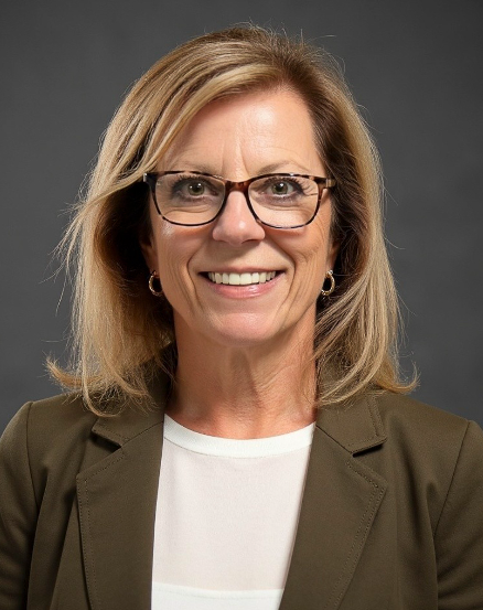 Smiling woman with glasses in professional attire.
