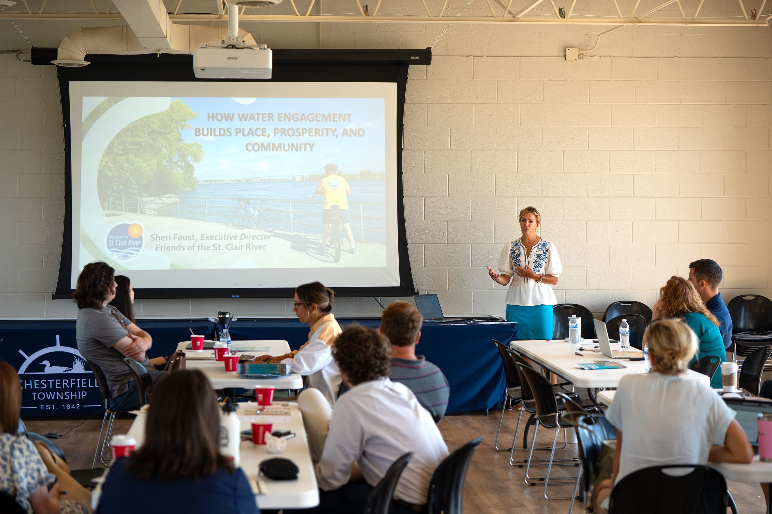 A speaker delivers a SEMCOG transportation planning presentation to workshop participants in a meeting room.